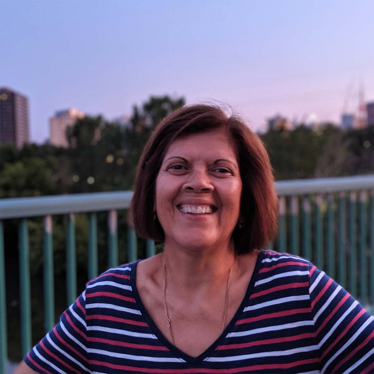 Woman on a bridge looking at the camera smiling